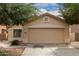 Tan single-story home with a two-car garage and desert landscaping at 10317 E Kiva Cir, Mesa, AZ 85209