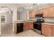 Well-lit kitchen with wood cabinets, stainless steel appliances, and vinyl flooring at 10317 E Kiva Cir, Mesa, AZ 85209