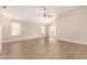 Bright living room featuring hardwood floors, large windows, and modern ceiling fan at 10317 E Kiva Cir, Mesa, AZ 85209