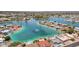 Aerial view of a lake community, showcasing waterfront homes, lush landscaping, and a fountain feature in the center of the lake at 10502 W Hutton Dr, Sun City, AZ 85351