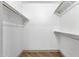 Empty walk-in closet with laminate floors and built-in shelving for organization at 10502 W Hutton Dr, Sun City, AZ 85351