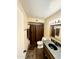 Bathroom featuring a granite countertop vanity, decorative mirror, and a shower with a dark curtain at 10852 N 39Th Ave, Phoenix, AZ 85029