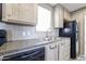 Kitchen showcasing a stainless steel sink, black appliances, and light wood cabinets with stylish handles at 10951 N 91St Ave # 6, Peoria, AZ 85345
