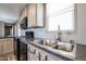 Bright kitchen with a window over the sink, black appliances, and light wood cabinets offering ample storage at 10951 N 91St Ave # 6, Peoria, AZ 85345