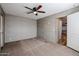 The main bedroom with carpet flooring, neutral walls, a ceiling fan, and a walk-in closet at 10951 N 91St Ave # 6, Peoria, AZ 85345