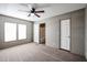 Large main bedroom with carpet flooring, two windows and doors leading to the bathroom and closet at 10951 N 91St Ave # 6, Peoria, AZ 85345