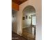 A view through an arched doorway to a bright room with wooden floors, a window, and neutral walls at 12512 N 85Th Ave, Peoria, AZ 85381