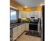 Efficient kitchen with stainless steel appliances, white cabinets, and a mosaic backsplash for a modern touch at 12512 N 85Th Ave, Peoria, AZ 85381