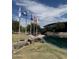 Scenic community space with flags, lush lawn, and pond with walkway at 12512 N 85Th Ave, Peoria, AZ 85381