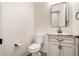 Powder room with a modern framed rectangular mirror, vanity with dark hardware, and tiled flooring at 14188 W Hope Dr, Surprise, AZ 85379