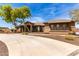 Beautiful desert home with an expansive driveway, mature trees, and well-maintained landscaping at 14188 W Hope Dr, Surprise, AZ 85379