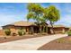 Stunning desert home with a circular driveway, lush landscaping, and a charming exterior at 14188 W Hope Dr, Surprise, AZ 85379