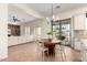 Open-concept kitchen and dining area, featuring natural light, brick accents, and access to the living room at 14188 W Hope Dr, Surprise, AZ 85379