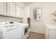 Well-organized laundry room with modern appliances, storage cabinets and light countertops at 14188 W Hope Dr, Surprise, AZ 85379