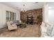 Inviting living room featuring a brick accent wall, stylish decor, and comfortable seating arrangements at 14188 W Hope Dr, Surprise, AZ 85379