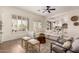 Bright living room with a large sectional sofa, decorative shutters, and views into the kitchen at 14188 W Hope Dr, Surprise, AZ 85379