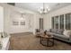 Inviting living room with neutral tones, carpet, modern lighting and plentiful windows with natural light at 14188 W Hope Dr, Surprise, AZ 85379