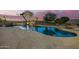 Stunning backyard featuring a sparkling pool with stone accents and lush landscaping at 14188 W Hope Dr, Surprise, AZ 85379
