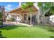 Inviting backyard with a covered patio, artificial grass, and mature trees at 155 W Knox Rd, Tempe, AZ 85284