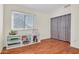 Bedroom with wood floors, large window, and closet with mirrored doors at 155 W Knox Rd, Tempe, AZ 85284