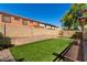 Spacious backyard featuring artificial grass, desert landscaping, and privacy wall at 16022 W Desert Mirage Dr, Surprise, AZ 85379