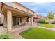 Charming backyard features covered patio, synthetic grass, and desert landscaping at 16022 W Desert Mirage Dr, Surprise, AZ 85379