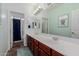 Bathroom with a double sink vanity, tiled floors, and shower and toilet in separate room at 16022 W Desert Mirage Dr, Surprise, AZ 85379