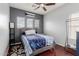 Comfortable bedroom features a ceiling fan, multiple windows, and stylish decor at 16022 W Desert Mirage Dr, Surprise, AZ 85379