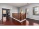 Upstairs hallway with wood flooring and views into the bedroom and out of the windows at 16022 W Desert Mirage Dr, Surprise, AZ 85379