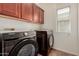 Convenient laundry room boasts overhead cabinets and modern washer and dryer units at 16022 W Desert Mirage Dr, Surprise, AZ 85379