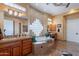 Elegant primary bathroom with and vanities, a large bathtub, and glass block window at 16441 S Mountain Stone Trl, Phoenix, AZ 85048