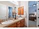 Bathroom featuring a double vanity, neutral-toned walls, and a glimpse into a bedroom at 16441 S Mountain Stone Trl, Phoenix, AZ 85048