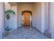 Elegant front entrance with custom wood door, columns, and travertine tile providing great curb appeal at 16441 S Mountain Stone Trl, Phoenix, AZ 85048