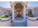 Elegant front entrance with a custom wood door, columns, and decorative planters providing great curb appeal at 16441 S Mountain Stone Trl, Phoenix, AZ 85048
