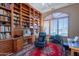 Inviting home office features custom built-in bookshelves, a desk, and large windows at 16441 S Mountain Stone Trl, Phoenix, AZ 85048
