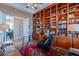 Spacious home office boasting custom built-in bookshelves and a comfortable seating area at 16441 S Mountain Stone Trl, Phoenix, AZ 85048