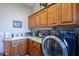 Functional laundry room featuring custom cabinets, a sink, countertop space, and a modern washing machine at 16441 S Mountain Stone Trl, Phoenix, AZ 85048
