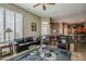 Living room with travertine floors, plantation shutters, and open access to the kitchen and dining area at 16441 S Mountain Stone Trl, Phoenix, AZ 85048