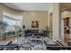 Bright living room featuring large windows, travertine flooring, and an open floor plan at 16441 S Mountain Stone Trl, Phoenix, AZ 85048