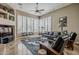 Inviting living room with travertine floors, plantation shutters, a ceiling fan, and a leather sofa for comfortable living at 16441 S Mountain Stone Trl, Phoenix, AZ 85048