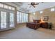 Serene main bedroom features ample natural light, French doors, and a decorative ceiling fan at 16441 S Mountain Stone Trl, Phoenix, AZ 85048