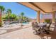 Back patio with an outdoor kitchen, seating, and views of the pool, spa, and desert landscape at 16441 S Mountain Stone Trl, Phoenix, AZ 85048
