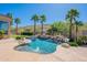 Backyard oasis showcasing a sparkling pool, rock waterfall feature, mature palm trees, and a sun-drenched patio at 16441 S Mountain Stone Trl, Phoenix, AZ 85048