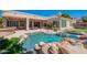 Resort-style pool featuring rock accents, mature landscaping, and an expansive patio with an outdoor dining area at 16441 S Mountain Stone Trl, Phoenix, AZ 85048