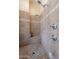Neutral-colored, tiled primary bathroom shower with dual shower heads and built-in bench at 16441 S Mountain Stone Trl, Phoenix, AZ 85048