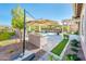 Backyard with an outdoor kitchen, shaded pergola, swimming pool, and a meticulously manicured lawn at 17054 W Saguaro Park Ln, Surprise, AZ 85387