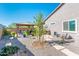 Landscaped backyard with a shaded patio area, decorative plants, and a serene outdoor space at 17054 W Saguaro Park Ln, Surprise, AZ 85387