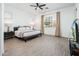 A cozy bedroom featuring neutral decor, tile floors, and a ceiling fan at 17054 W Saguaro Park Ln, Surprise, AZ 85387