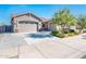 Beautiful home featuring a three-car garage and a cozy front patio, perfect for enjoying the outdoors at 17054 W Saguaro Park Ln, Surprise, AZ 85387