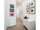 Bright hallway with tiled floors and unique framed wall art with white dresser at 17054 W Saguaro Park Ln, Surprise, AZ 85387